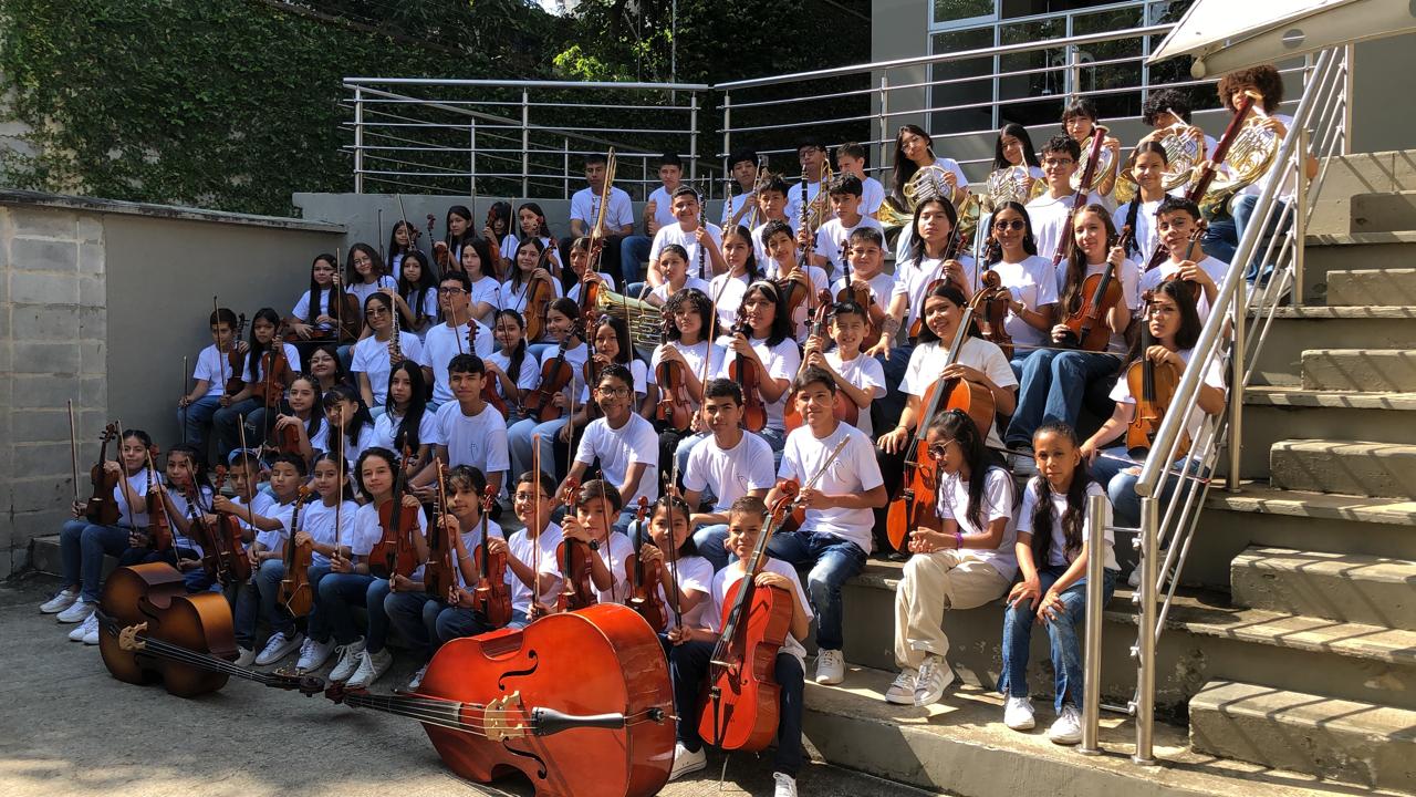 Chicos de la Fundación Notas de Paz con instrumento musical en ensayo comunitario Donar un instrumento musical