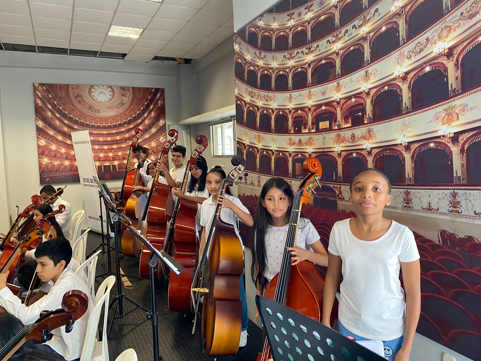 Chicos tocando el chelo en concierto de la preorquesta Dona un instrumento